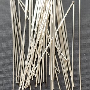 May include: A pile of silver-colored head pins, used for jewelry making.