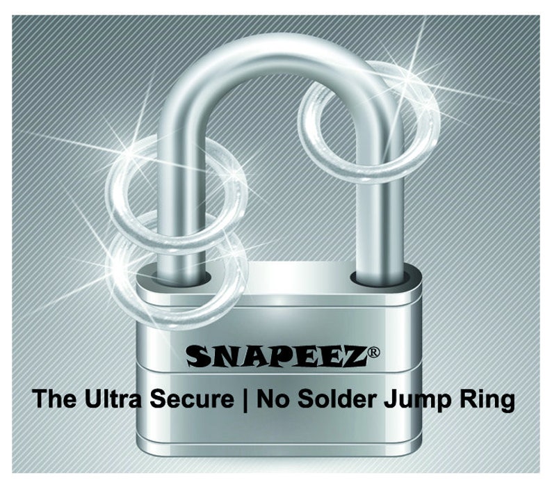 Puede incluir: Un candado plateado con dos anillos de salto plateados alrededor del grillete. El candado tiene el texto "SNAPEEZ&reg;" y "The Ultra Secure | No Solder Jump Ring" en el cuerpo.