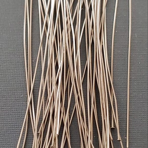 May include: A pile of silver-colored head pins, used for jewelry making.