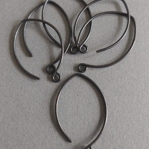 May include: Five black metal earring hoops with a small loop at the bottom of each hoop.