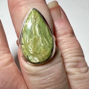 May include: A teardrop-shaped green gemstone ring set in sterling silver. The gemstone has a swirling, marbled pattern.