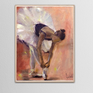 May include: A ballerina in a white tutu and black leotard is tying her pointe shoes. The background is a warm peach color.