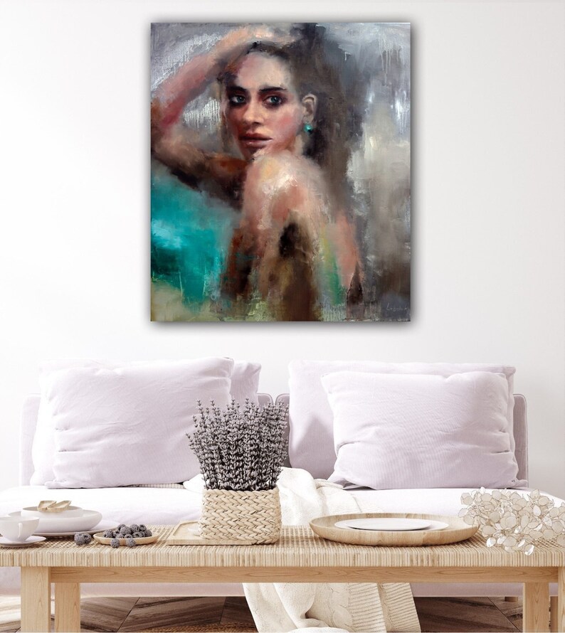 Puede incluir: Una pintura de una mujer con el pelo largo y oscuro, que lleva un pendiente turquesa. Ella est&aacute; mirando directamente al espectador con una expresi&oacute;n suave. El fondo es una mezcla de tonos grises y azules.