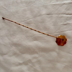 May include: A gold cocktail pick with a twisted stem and a flower-shaped head. The pick is designed for garnishing drinks, adding a touch of elegance to any cocktail.