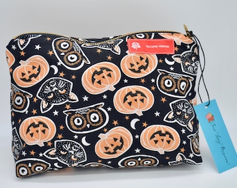 May include: Black zippered pouch with a Halloween print featuring orange pumpkins, black cats, and owls on a black background. The pouch has a gold zipper and a red tag with the text "Sew Long Handmade".