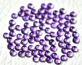 May include: A collection of round, purple amethyst cabochons. The cabochons are smooth and have a slight iridescent sheen.