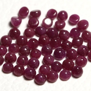 May include: A collection of round, cabochon-cut ruby gemstones. The rubies are a deep red color and have a smooth, polished finish.
