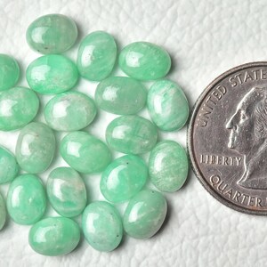 Peut inclure: Une collection de 20 pierres pr&eacute;cieuses vertes de forme ovale, chacune d'environ la taille d'une pi&egrave;ce de 25 cents am&eacute;ricaine. Les pierres ont une apparence translucide l&eacute;g&egrave;rement nuageuse.