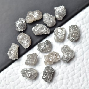 May include: A collection of rough, grey diamonds, also known as raw diamonds, with a silvery sheen. These natural diamonds are unpolished and have a unique, irregular shape.