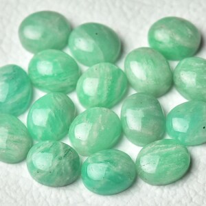 May include: A collection of 14 smooth, oval-shaped green gemstones. The stones have a translucent, light green color and a slightly cloudy appearance.