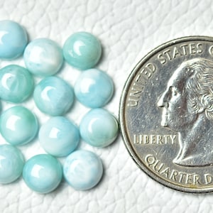Puede incluir: Una colecci&oacute;n de 16 piedras preciosas cabuj&oacute;n de color azul claro y blanco, cada una del tama&ntilde;o de una moneda de 25 centavos de d&oacute;lar estadounidense.