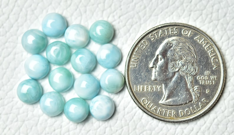 Puede incluir: Una colecci&oacute;n de 16 piedras preciosas cabuj&oacute;n de color azul claro y blanco, cada una del tama&ntilde;o de una moneda de 25 centavos de d&oacute;lar estadounidense.