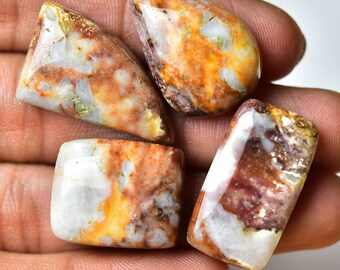 May include: Four polished, white, brown, and orange agate cabochons with a variety of patterns and textures.
