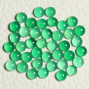 Puede incluir: Una colecci&oacute;n de 40 cabujones redondos de piedra preciosa verde. Los cabujones son lisos y pulidos, con una ligera variaci&oacute;n en el color y la translucidez.