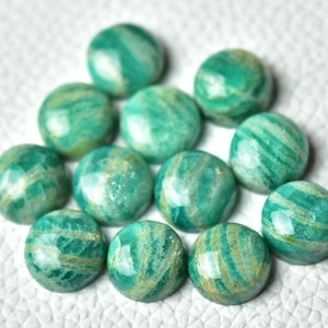 May include: A collection of 12 round, green and white amazonite cabochons. The cabochons are smooth and polished, with a variety of green and white patterns.