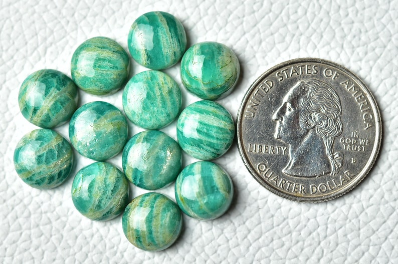May include: A collection of 14 green and white amazonite cabochons, each approximately the size of a UK 20 pence coin.