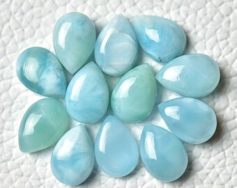 May include: A collection of 12 teardrop-shaped blue and green gemstone cabochons. The cabochons are smooth and polished, with a pearlescent sheen.