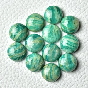 May include: A collection of 12 round, green amazonite cabochons with white and gold striations. The cabochons are smooth and polished.