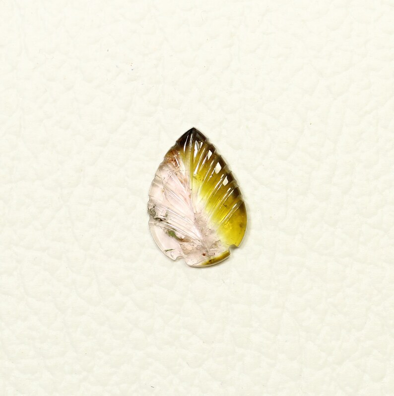 May include: A teardrop-shaped carved gemstone pendant with a pink and green color gradient. The gemstone is carved to resemble a leaf with a detailed vein pattern.