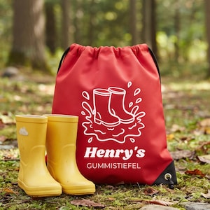 Op de afbeelding: Een rode rugzak met trekkoord voorzien van een witte afbeelding van twee regenlaarzen die in een plas spatten, met de tekst Henry's GUMMISTIEFEL eronder. Naast de tas staat een paar gele regenlaarzen met een klein wolkicoontje.