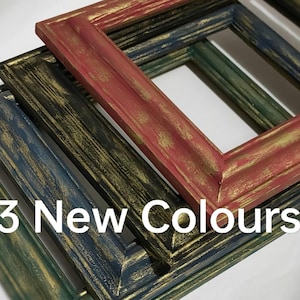 May include: Close-up of three wooden picture frames in new colours. The frames are painted in red, dark green, and blue, with gold accents. The text "3 New Colours" is displayed in white.