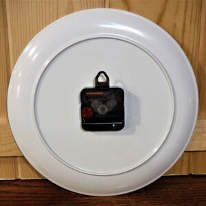 May include: A handmade wooden sign displaying the word "Welcome" in a handwritten font. The white-painted sign has a distressed finish and a small heart detail. Suitable for indoor or outdoor display.