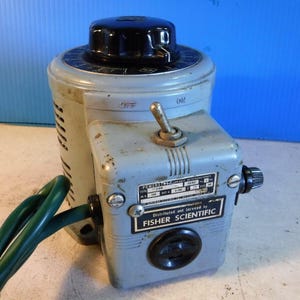 May include: A gray and black variable voltage transformer with a black knob and a green power cord. The transformer has a label that reads "Distributed and Serviced by FISHER SCIENTIFIC".