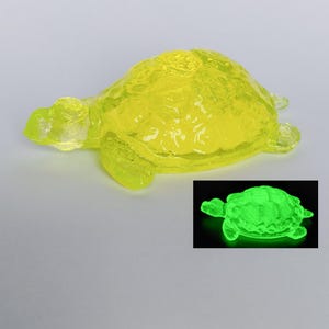 May include: A yellow glass turtle figurine that glows green in the dark.