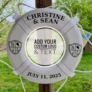 May include: White life preserver with the text "CHRISTINE & SEAN" and "JULY 11, 2025". It features a central circle for a custom logo and text, and two crests with a golf club, anchor, and the letter "B".