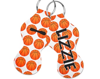 May include: Two white keychains with orange basketballs printed on them. One keychain has the name "LIZZIE" printed on it.