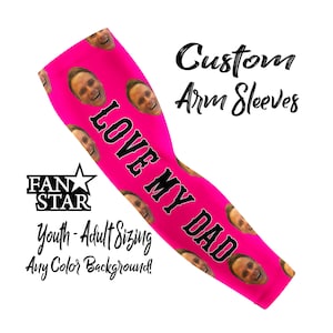 May include: A bright pink custom arm sleeve with the text "LOVE MY DAD" in black. The sleeve features multiple images of a smiling person's face. The text "Custom Arm Sleeves" and "Youth-Adult Sizing" are also visible.