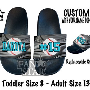 May include: A pair of black and grey custom slides with a baseball design. One slide has the name "Dakota" and the other has the number "#15". The slides are available in toddler size 8 to adult size 13.