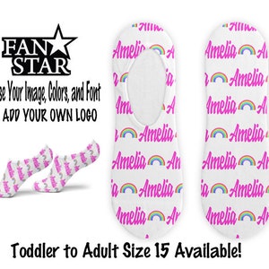 Puede incluir: Un par de calcetines invisibles blancos con un arcoíris rosa y el nombre "Amelia" repetido en letras rosas. Los calcetines están disponibles en tallas de niño pequeño a adulto hasta la talla 15.