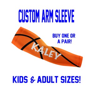 May include: Orange and black basketball arm sleeve with the name "KALEY" printed in white.  CUSTOM ARM SLEEVE, BUY ONE OR A PAIR!, KIDS & ADULT SIZES! are printed in blue text.