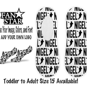Puede incluir: Un par de calcetines invisibles blancos con un patrón en blanco y negro. El patrón presenta el nombre "Nigel" repetido varias veces con una figura de palo de una persona sosteniendo un palo de lacrosse. El texto "Fan Star" está en la parte superior de la imagen con una estrella y el texto "Elige tu imagen, colores y fuente o agrega tu propio logotipo". El texto "Talla de niño pequeño a adulto 15 disponible!" está en la parte inferior de la imagen.