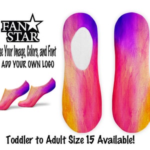 Puede incluir: Un par de calcetines invisibles coloridos con un diseño degradado en tonos amarillos, naranjas, rosas y morados. Los calcetines están disponibles en tallas desde la talla de niño pequeño hasta la talla de adulto 15. El texto "FAN STAR" se muestra encima de los calcetines. El texto "Choose Your Image, Colors, and Font OR ADD YOUR OWN LOGO" se muestra debajo de los calcetines.