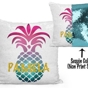 May include: White sequin pillow with a pineapple design in shades of pink, blue, and green. The name "PAMELA" is printed in gold glitter letters. The non-printed side of the pillow is teal sequins.