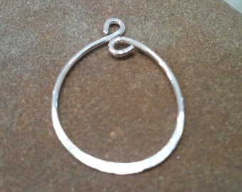 Könnte beinhalten: Ein silberfarbener Metallring mit einer verdrehten Drahtschlaufe oben. Der Ring ist glatt und hat eine leicht gehämmerte Textur.