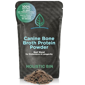 Op de afbeelding: Een zwarte zak Canine Bone Broth Protein Powder, Beef Blend, voor honden. De zak heeft een groen en wit rond label met de tekst "100% natuurlijk, geen MSG, geen conserveringsmiddelen". Elke zak bevat 50 gram poeder. De merknaam is Holistic Bin.