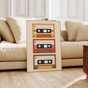 May include: A beige poster with three vintage cassette tapes stacked vertically. Each tape has a brown, orange, and yellow design with the letter "A" printed on the top left corner.