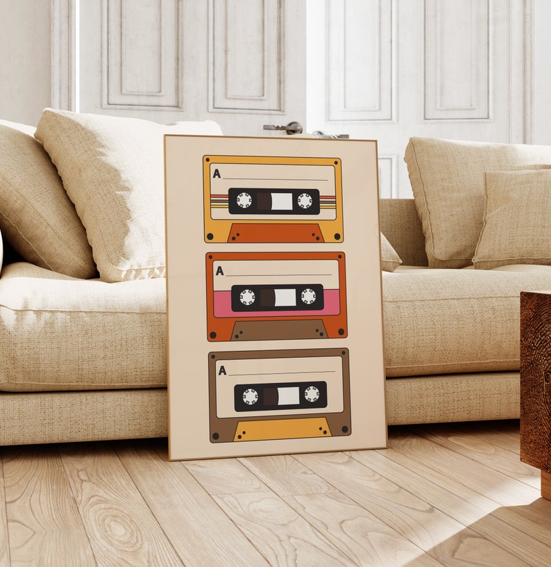 May include: A beige poster with three vintage cassette tapes stacked vertically. Each tape has a brown, orange, and yellow design with the letter "A" printed on the top left corner.