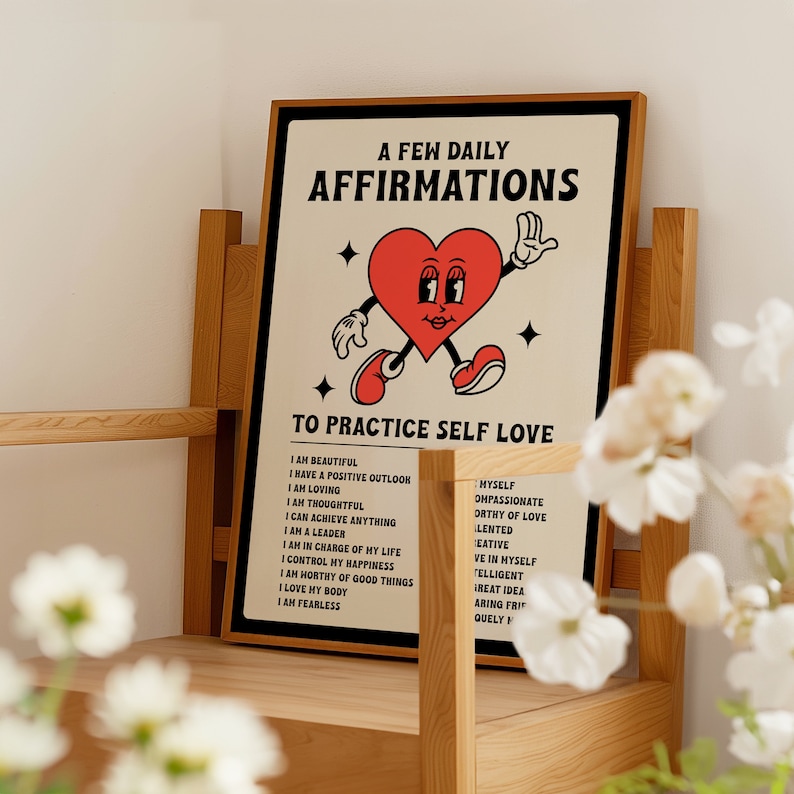 May include: A framed poster with the text "A Few Daily Affirmations To Practice Self Love." The poster features a cartoon heart character with arms and legs. The poster is in a wooden frame.