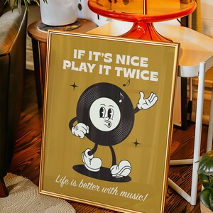 Puede incluir: P&oacute;ster enmarcado con un dise&ntilde;o de disco de vinilo de dibujos animados retro. El p&oacute;ster dice "IF IT'S NICE PLAY IT TWICE" y "Life is better with music!". La obra de arte presenta un personaje de disco en blanco y negro con una nota musical.