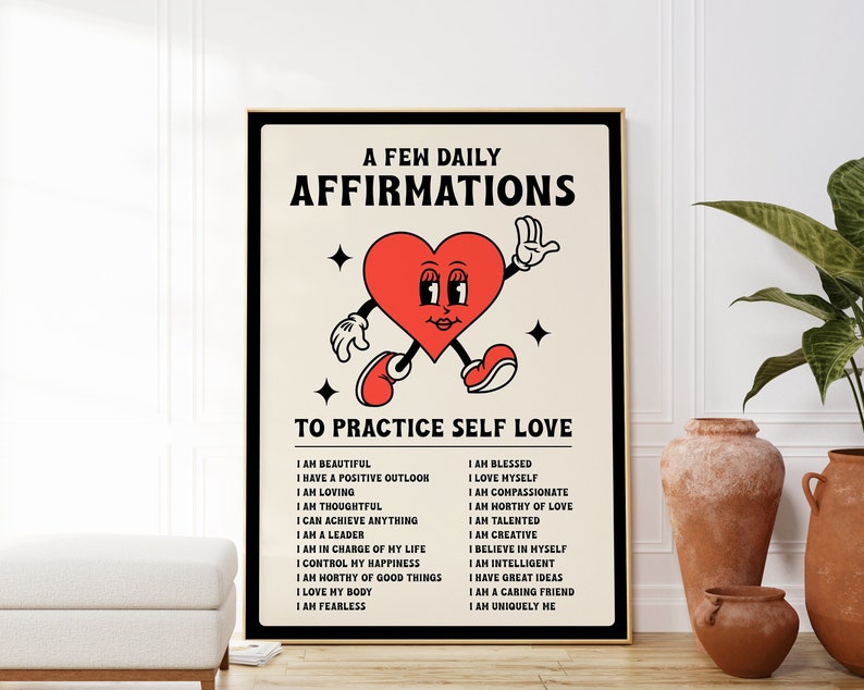 May include: A framed poster with a retro design featuring a red heart character with arms and legs. The poster reads "A Few Daily Affirmations To Practice Self Love" with a list of positive affirmations below. The poster is in a black frame.