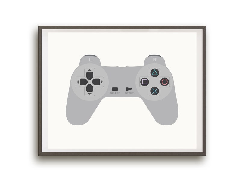 May include: A framed print of a gray video game controller with black buttons and a white background. The controller has the words "Select" and "Start" printed on it.