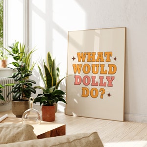 K&ouml;nnte beinhalten: Ein beiger Poster mit dem Text "WHAT WOULD DOLLY DO?" in orangefarbenen und rosafarbenen Buchstaben mit einem Stern auf jeder Seite des Textes.