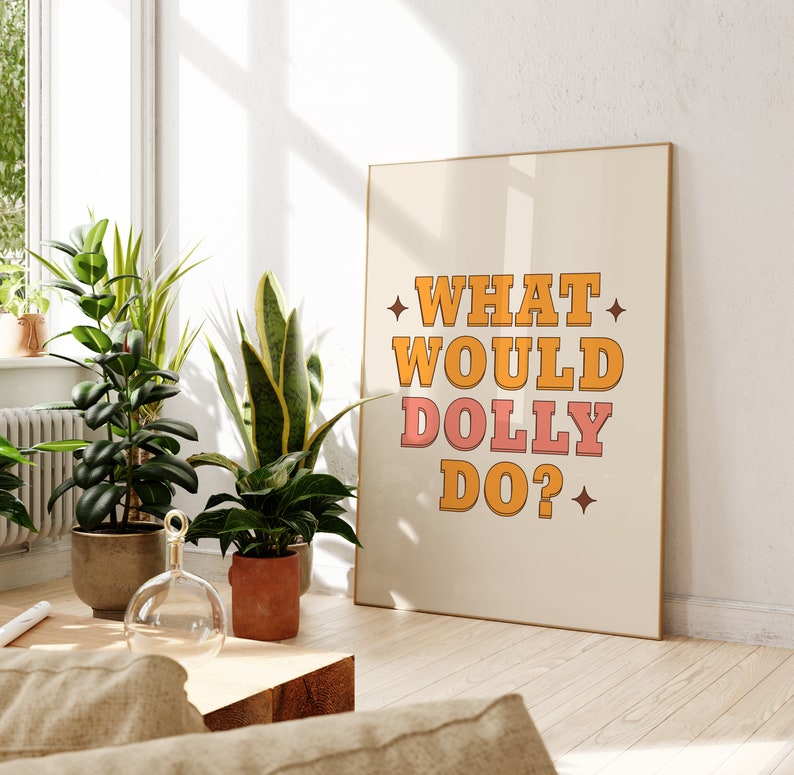 K&ouml;nnte beinhalten: Ein beiger Poster mit dem Text "WHAT WOULD DOLLY DO?" in orangefarbenen und rosafarbenen Buchstaben mit einem Stern auf jeder Seite des Textes.