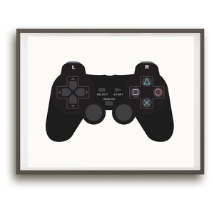 May include: A black video game controller with buttons and a directional pad, framed in a gray frame.