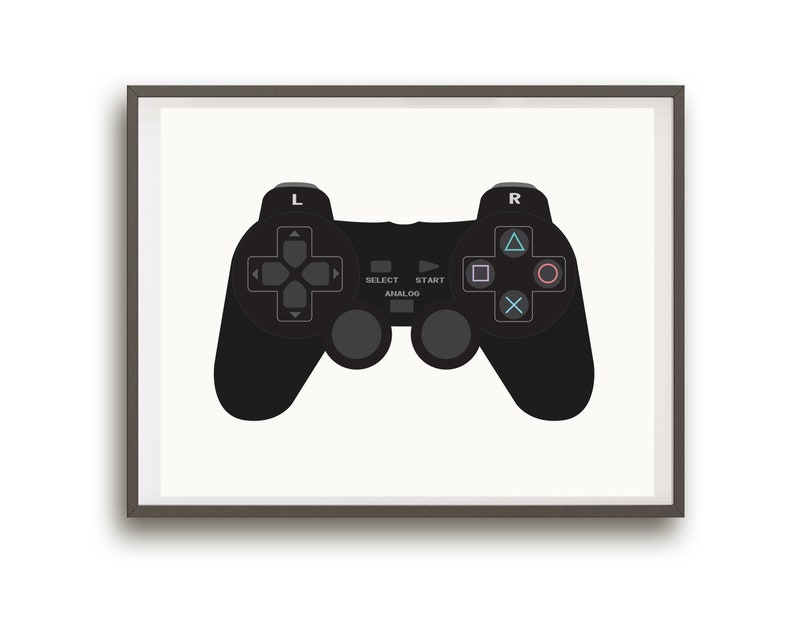 May include: A black video game controller with buttons and a directional pad, framed in a gray frame.