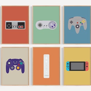 Könnte beinhalten: Sechs gerahmte Drucke mit minimalistischen Illustrationen klassischer Videospiel-Controller. Jeder Controller ist vor einem einfarbigen Hintergrund platziert, darunter Rot, Grün, Blau, Beige, Orange und Gelb. Für Gamer.